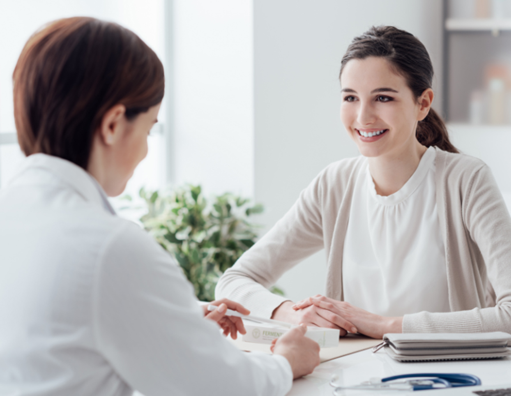 Smiling woman consulting with doctor