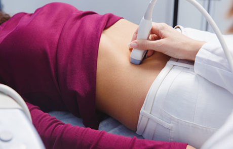 Patient receiving abdominal ultrasound during medical exam