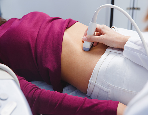 Patient receiving abdominal ultrasound during medical exam